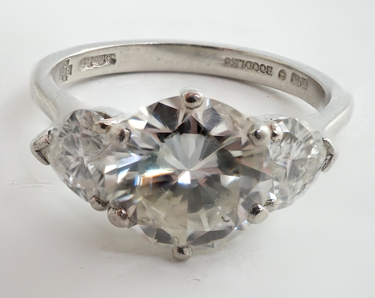 A modern Boodles & Dunthorne platinum and single stone diamond ring, with two stone heart shaped diamond set shoulders